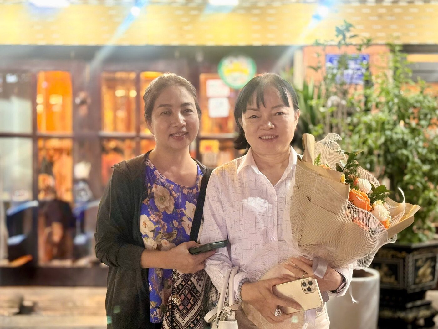 Luật sư Bình Minh chụp ảnh cùng một người phụ nữ cầm hoa